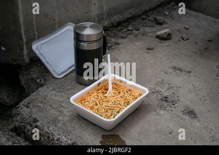 Cheap fast food for poor and homeless people in an old abandoned building Stock Photo