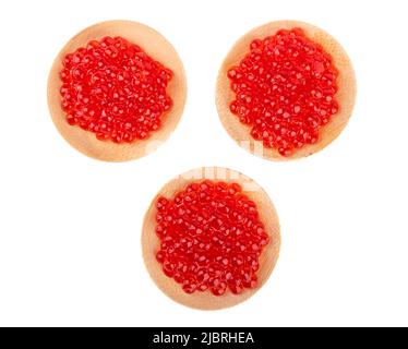 Three wooden mini plates with red caviar isolated on a white background. Top view, copy space. Stock Photo