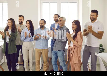 Team of happy and joyful colleagues applauds, expressing their gratitude after a successful meeting. Stock Photo