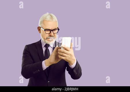 Mature grey-haired businessman using cellphone device Stock Photo