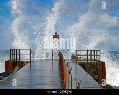 Lighthouse in swell with splashing waves on the Danish North Sea coast of Vorupør Stock Photo