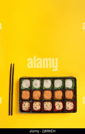 Japanese mochi dessert in a plastic box on a yellow background Stock Photo