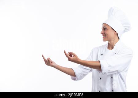 Woman chef pointing with fingers isolated on white background with copy space. Stock Photo