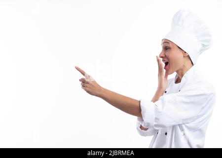 Woman chef surprised pointing  with finger  isolated on white background with copy space . Stock Photo