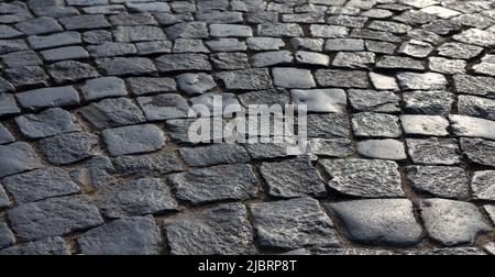 Shiny black stone pavement. Photo background with selective focus on a foreground Stock Photo