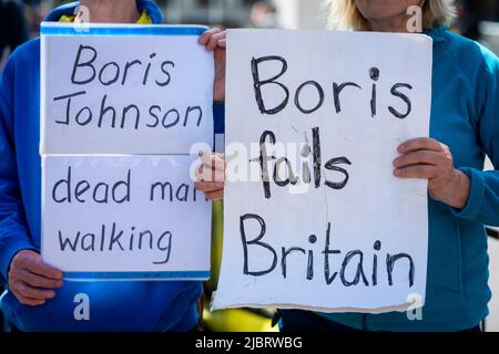 London, UK.  8 June 2022.  Protesters hold up signs in Westminster with a message to Boris Johnson who is currently in the Houses of Parliament facing Prime Minister’s  Questions (PMQs).  It is the first time that the Prime Minister has faced other MPs since narrowly winning a ballot of confidence by fellow Conservative MPs.  Credit: Stephen Chung / Alamy Live News Stock Photo