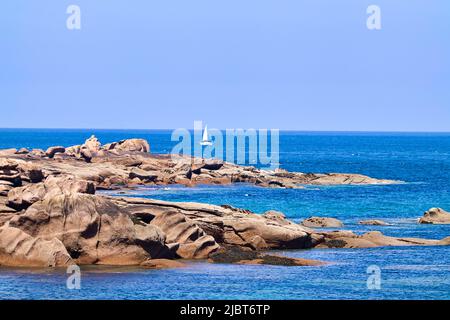 France, Cotes d'Armor, Côte de Granit Rose, Perros Guirec, Ploumanac'h, Renote island, granite rock on the beach, in the distance a sailboat on the sea Stock Photo