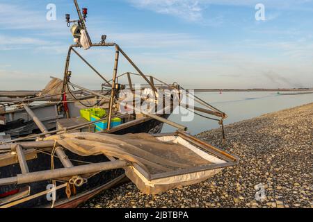 France, Somme, Le Hourdel, this trawler could not return to the port of Le Hourdel because of the low tide which did not offer enough depth for its draft; it had to run aground on the pebble beach to wait for the return of the tide. It is a boat equipped to fish for shrimp by scraping the bottom with nets Stock Photo