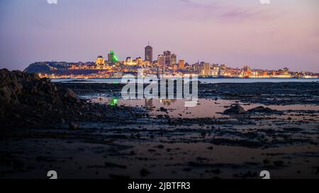 Vantage viewpoint at low tide over Quebec city's coast at blue hour viewed from Île d'Orléans, Quebec, Canada Stock Photo