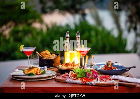 Luxury dinner served on table with fresh seafood, cold cuts and cocktail glasses Stock Photo
