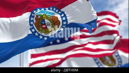 The Missouri state flag waving along with the national flag of the United States of America. In the background there is a clear sky. Missouri is a sta Stock Photo
