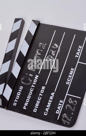 Close-up vertical shot black cinema clapboard with chalk handwriting. Isolated on white background. Stock Photo
