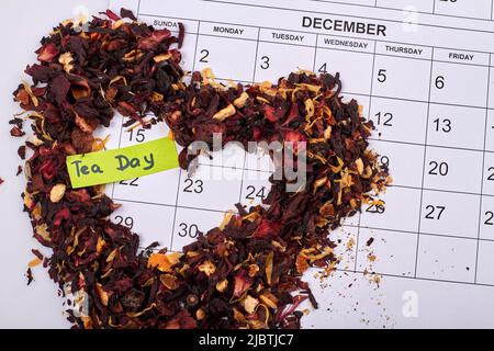 Dry hibiscus petals in the shape of heart on the month calendar. Tea day concept. Stock Photo
