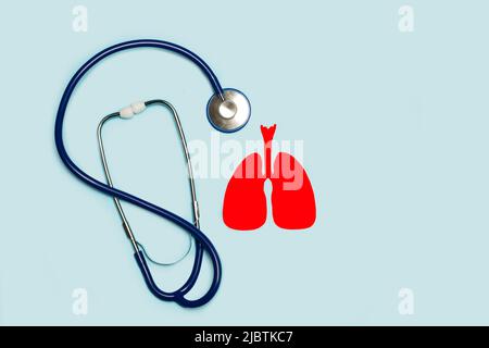 Red paper lungs shape and a stethoscope on a light blue background with copy space Stock Photo