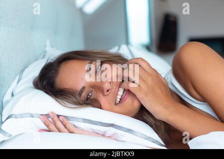 Portrait of caucasian beautiful woman lying on the bed at home Stock Photo