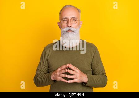 Photo of cute attentive age gentleman wear khaki sweater spectacles listening you fingers together isolated yellow color background Stock Photo