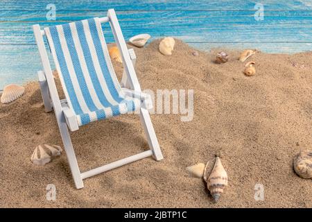 Seashells on the sand on a blue background. Summer vacation, beach, relaxation, sea, ocean, travel concept. Stock Photo