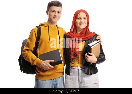 Young male and female student with a hijab holding books isolated on white background Stock Photo