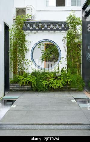 Bamboo and a wall with a hollow center in a Chinese classical garden Stock Photo