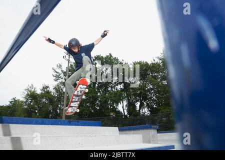 young man skateboarding  at the Keyport skatepark, Keyport New Jersey. Getting some air. Stock Photo