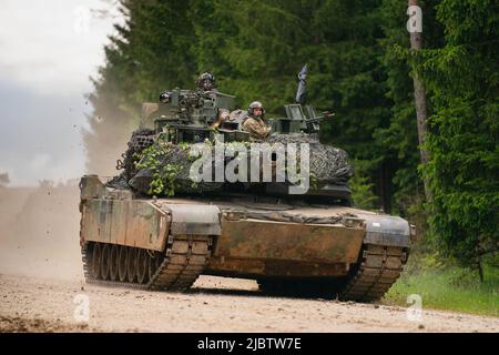 Hohenfels, Germany. 08th June, 2022. A US Army M1 Abrams tank drives across a road during a multinational exercise at the Hohenfels training area. Credit: Nicolas Armer/dpa/Alamy Live News Stock Photo