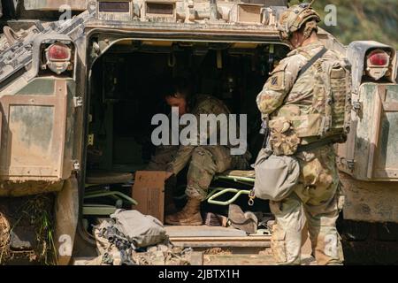 Hohenfels, Germany. 08th June, 2022. U.S. soldiers stand together during a multinational exercise at Hohenfels Training Area. Credit: Nicolas Armer/dpa/Alamy Live News Stock Photo