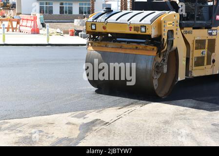 IRVINE, CALIFORNIA -6 JUNE 2022: Closeup of a steam roller on new blacktop surface in a parking lot. Stock Photo