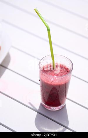 Glass with natural smoothie of red fruits, strawberry and blueberries Stock Photo