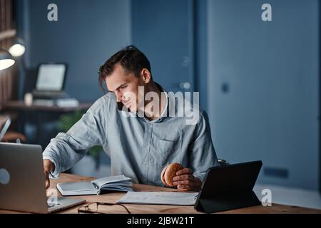 young businessman talking on a smartphone and using a digital tablet. Stock Photo