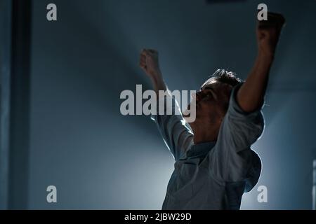 tired young businessman stretching during night work. Stock Photo