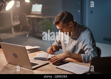 young businessman is working on a new project at night. Stock Photo