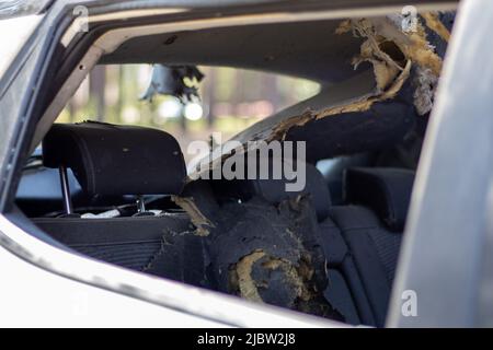 A car after an accident with a broken rear and side glass, view from the rear window. Broken window in a vehicle. The wreckage of the saloon, a detail Stock Photo