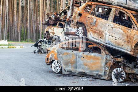 A lot of rusty burnt cars in Irpen, after being shot by the Russian military. Russia's war against Ukraine. Cemetery of destroyed cars of civilians wh Stock Photo