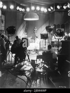 Cinematographer BARNEY McGILL Director MICHAEL CURTIZ and RICHARD BARTHELMESS on set candid with Movie Crew during filming of ALIAS THE DOCTOR 1932 director MICHAEL CURTIZ First National Pictures / Warner Bros. Stock Photo