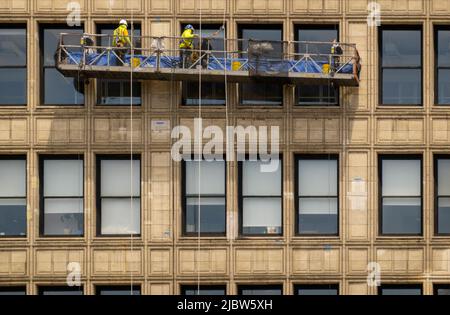 washing windows on a large building in Union Square district of Manhattan NYC Stock Photo