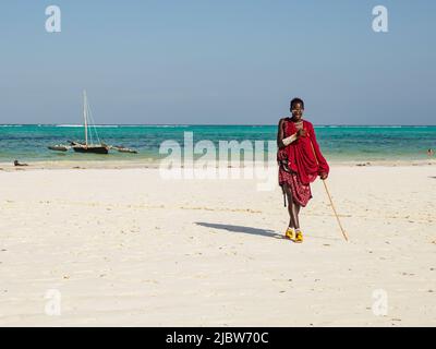 Zanzibar, Tanzania - January 2021: African Maasai warrior in traditional dress on a sandy beach. Africa Stock Photo