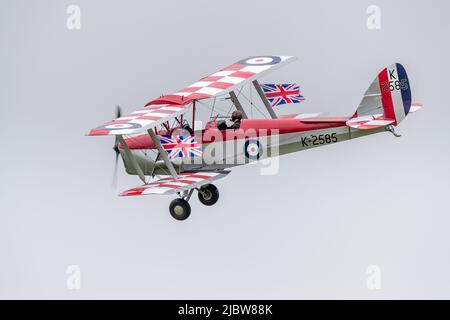 1931 DH82A Tiger Moth (K2585) flying at Shuttleworth with Union Jack flags celebrating the Queens Platinum Jubilee on the 5th June 2022 Stock Photo