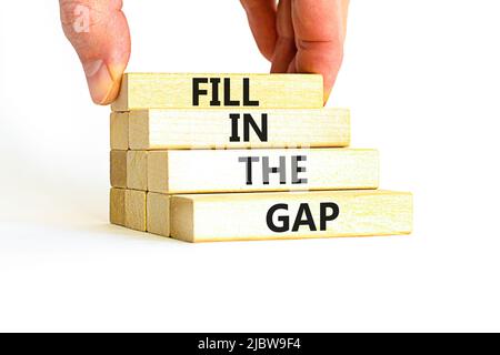 Fill in the gap symbol. Concept words Fill in the gap on wooden blocks on a beautiful white table white background. Businessman hand. Business, motiva Stock Photo