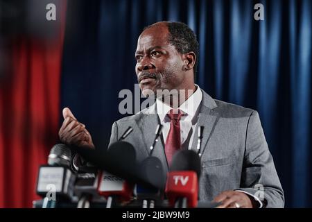 African American mature businessman in suit speaking behind the podium during his interview for television Stock Photo