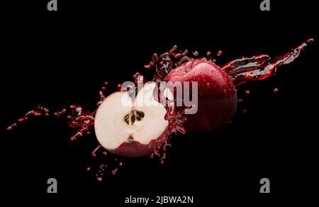 red apples in juice splash on a black background with clipping path. Stock Photo