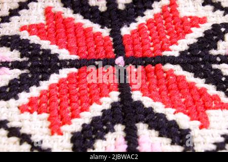 Embroidered piece by cross-stitch geometric pattern. Ukrainian ethnic ornament Macro shoot Stock Photo