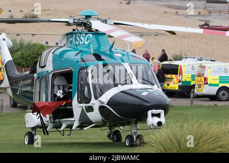 Eastbourne, East Sussex, UK. 8th June, 2022. The Sussex and Kent Air ambulance assisted by ground teams attends the Wish tower, Western lawns, after three people were recovered from the sea this afternoon. All three were transported to hospital, two to the Hasting Conquest hospital in a less serious condition and one described as serious by air ambulance to the major trauma centre, Kings College hospital London. Credit: Newspics UK South/Alamy Live News Stock Photo