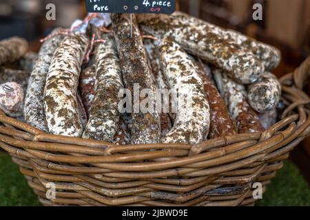 Stacks of dry-cured sausages - saucisson, typically made of pork, or a mixture of pork and other meats. Stock Photo