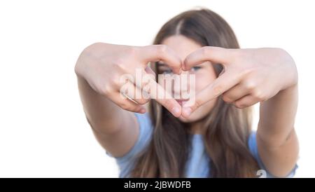 Selective focus of a young girl's hands forming a heart with her fingers on white background. Gesture and expression of love Stock Photo