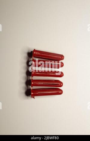 cluster of red wall plugs isolated on a plain white background Stock Photo