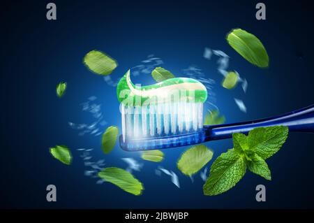 Toothbrush with toothpaste. Mint toothpaste. Mint leaves around toothbrush and paste. Toothpaste advertisement. Stock Photo