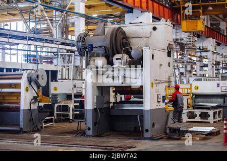 Technician operators working with with sheet metal on CNC hydraulic press brake. Stock Photo