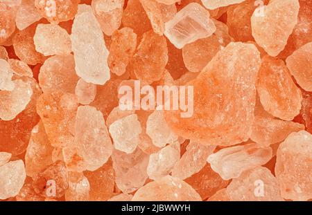 Pink orange crystals - rough Himalayan rock salt - 1.5x magnification, image width 23mm. Abstract science or chemistry background Stock Photo