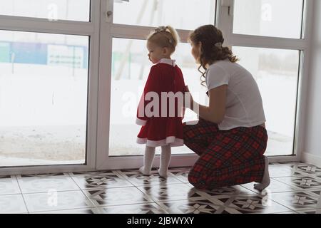 Child girl with cochlear implant plays at home with mother. Hear impairment and diversity and hearing aid copy space and place for advertising Stock Photo