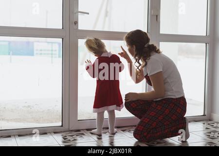 Child girl with cochlear implant plays at home with mother. Hear impairment and diversity and hearing aid copy space and place for advertising Stock Photo